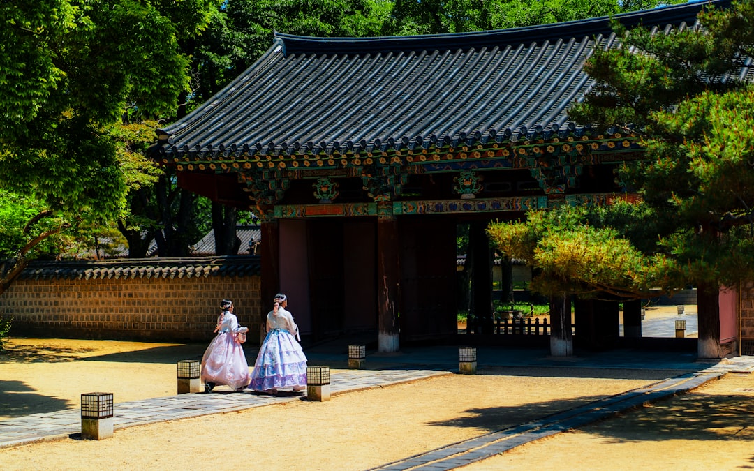 a couple of women walking down a street next to a building