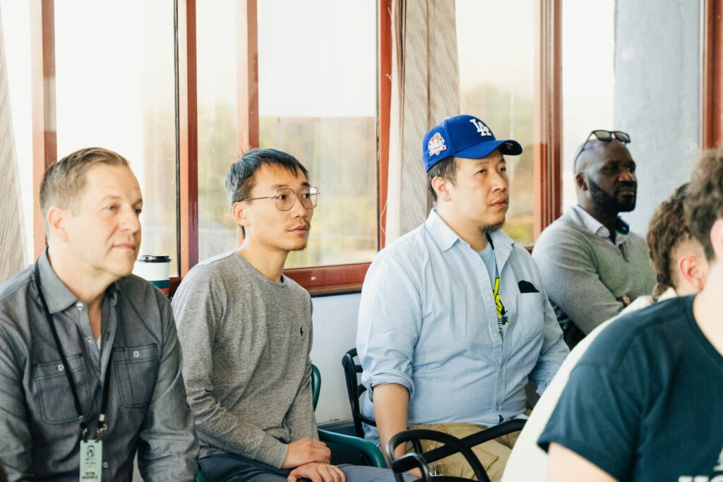 employees practicing Korean conversation in small group during office training session, collaborative mood, realistic high quality photo