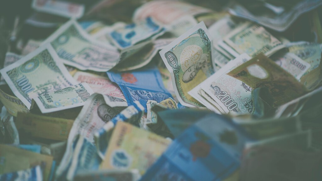 Korean won banknotes and coins arranged on a wooden table with travel items