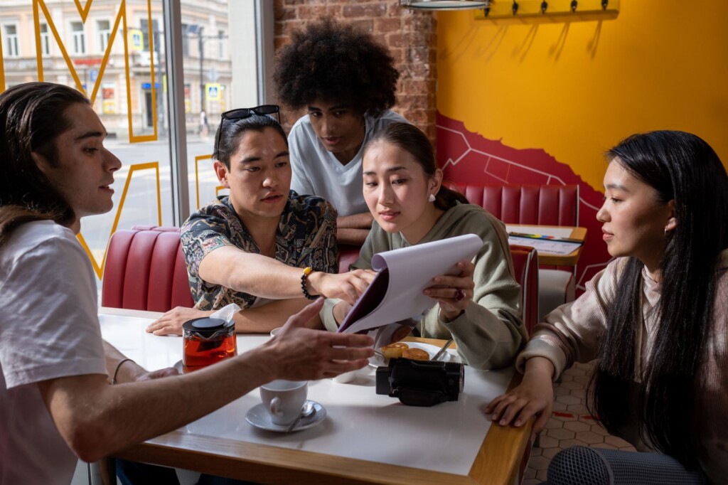 A young Korean woman and an older Korean man discussing study strategies over coffee in a cafe