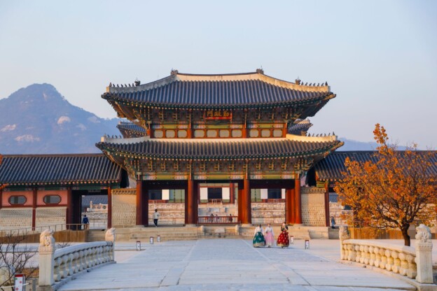 Korean mountain temple surrounded by red and gold autumn foliage