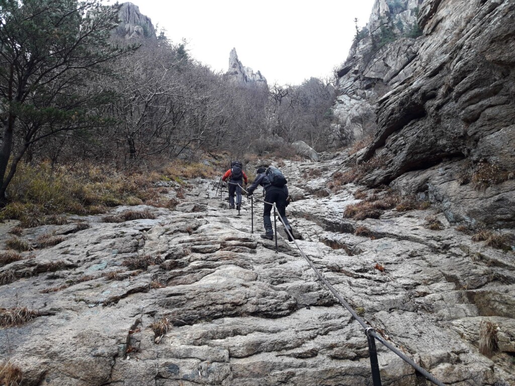 Two Korean hikers smiling on an autumn mountain trail
