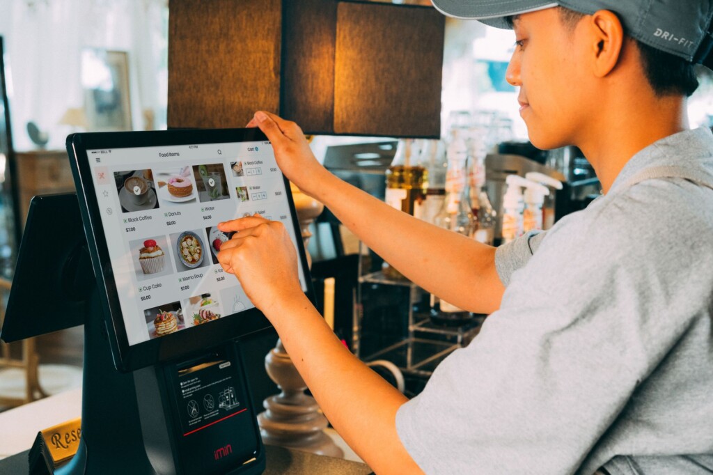 A young Korean server taking an order from an older woman pointing at dishes